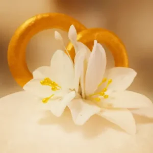 Элегантное сахарное украшение в виде белой лилии с золотыми тычинками и кольцами